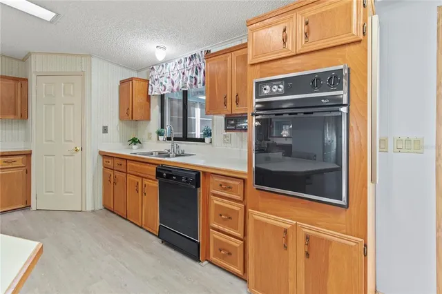 a kitchen with stainless steel appliances a sink a counter top space and a large window