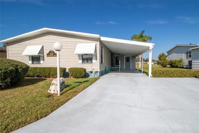 a view of a house with a yard and potted plants