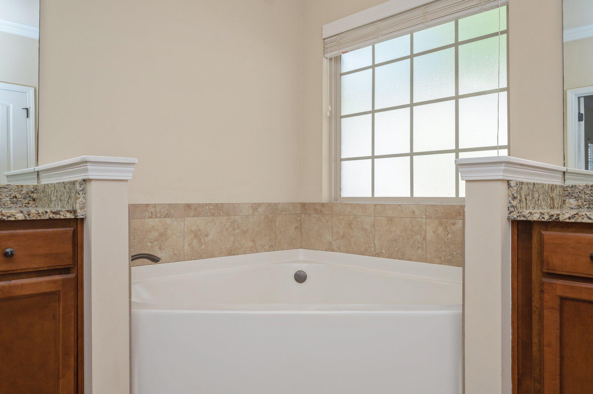 4434 Mirada Way Crestview, FL 32539 - Photo 11 of 42 a bathroom with a bathtub and next to a window