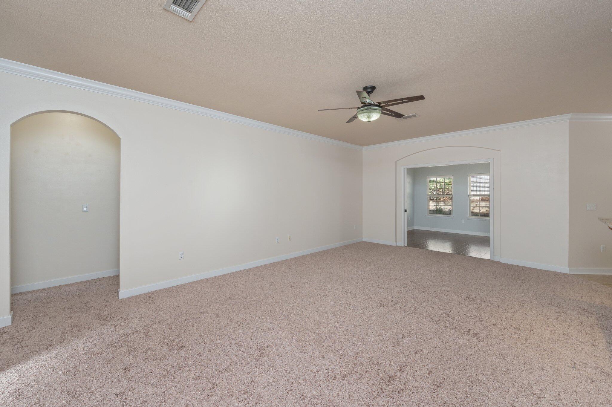 4434 Mirada Way Crestview, FL 32539 - Photo 16 of 42 an empty room with a chandelier fan and windows