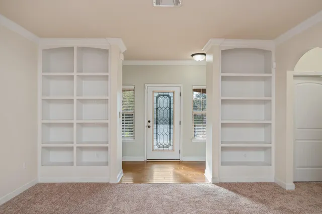 a view of an empty room with cabinet and a window