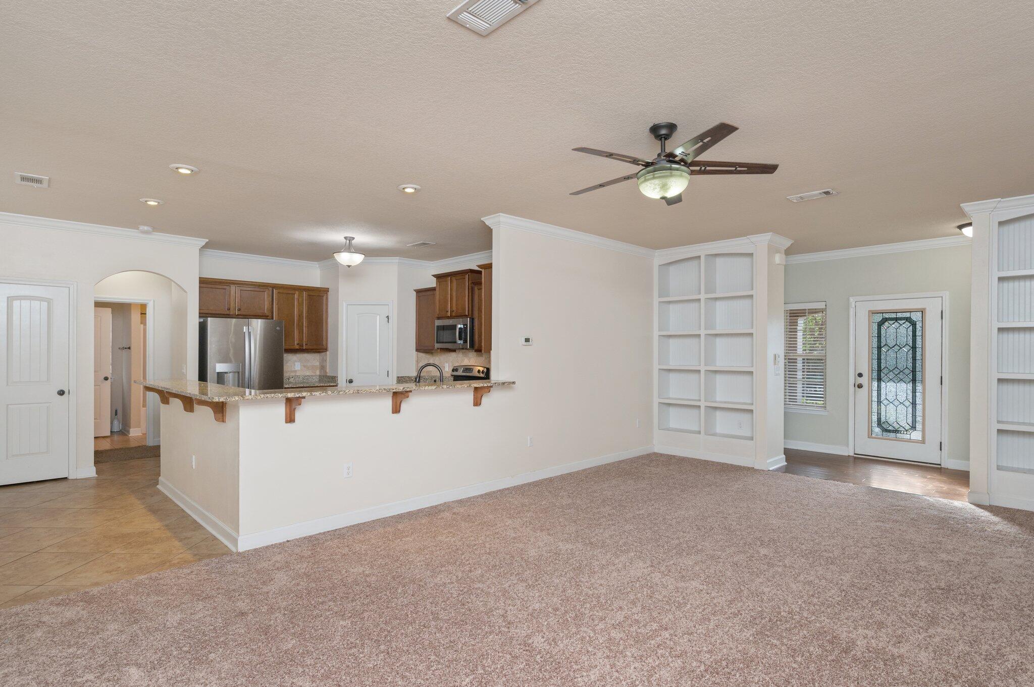 4434 Mirada Way Crestview, FL 32539 - Photo 18 of 42 a view of empty room with wooden floor and ceiling fan