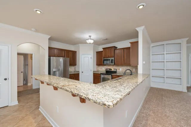 a large kitchen with kitchen island a sink stainless steel appliances and cabinets