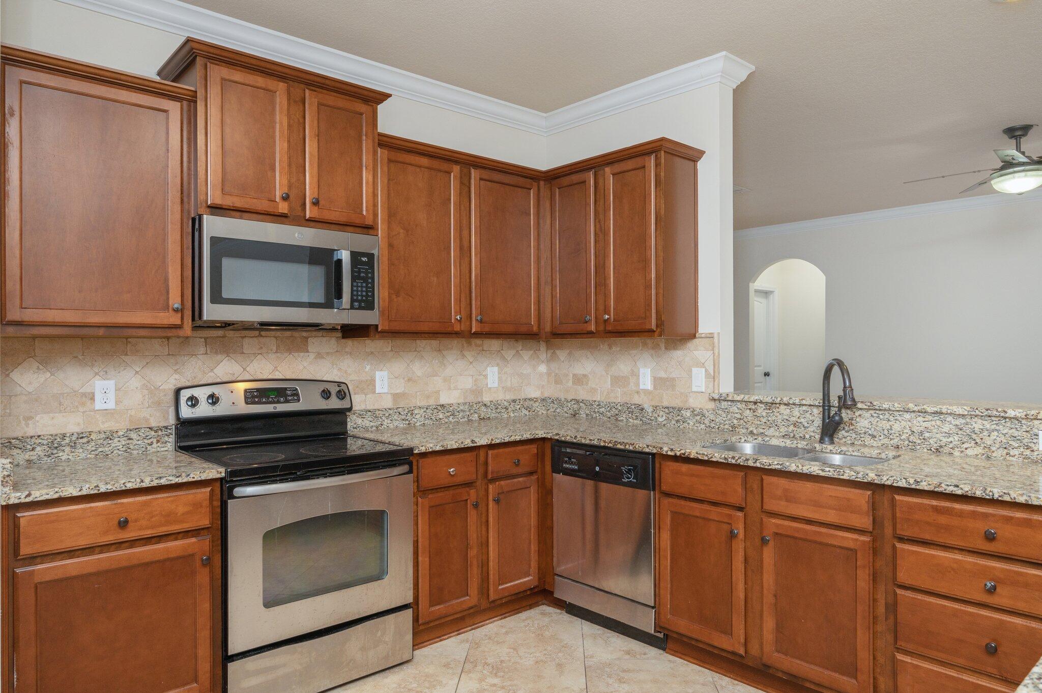 4434 Mirada Way Crestview, FL 32539 - Photo 22 of 42 a kitchen with granite countertop stainless steel appliances a stove microwave and sink