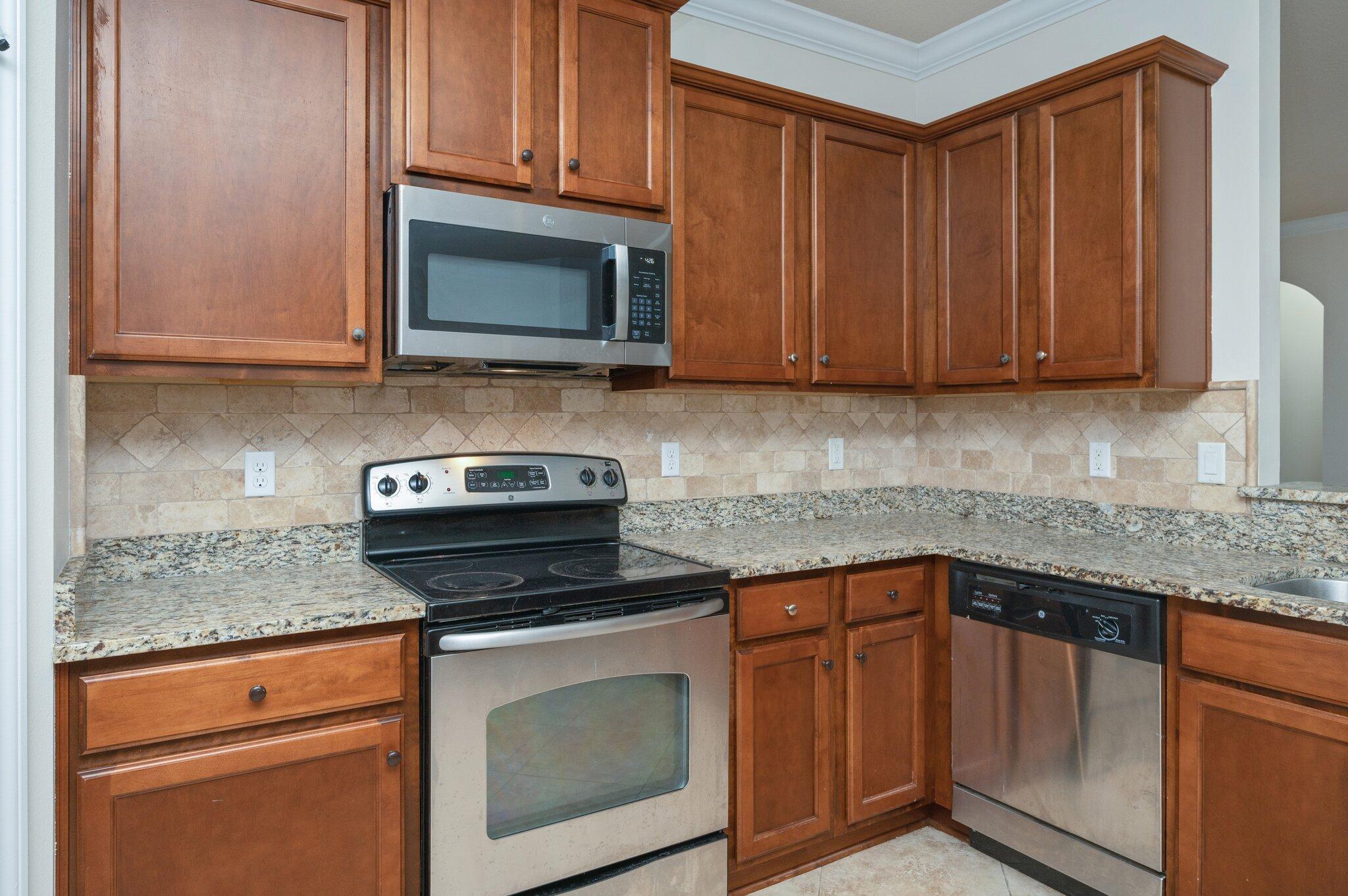 4434 Mirada Way Crestview, FL 32539 - Photo 25 of 42 a kitchen with granite countertop wood cabinets and stainless steel appliances