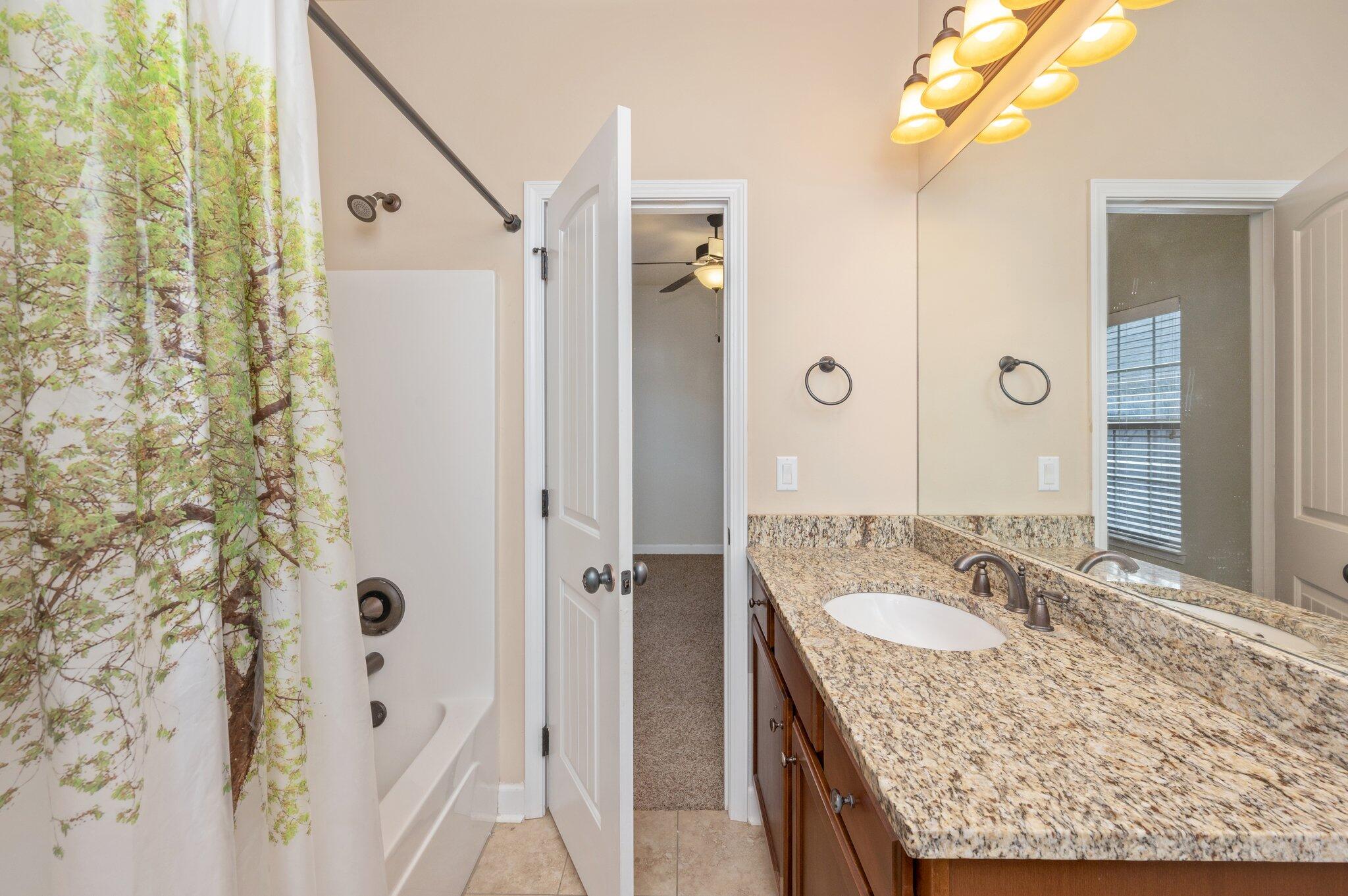 4434 Mirada Way Crestview, FL 32539 - Photo 31 of 42 a bathroom with a granite countertop shower sink and mirror
