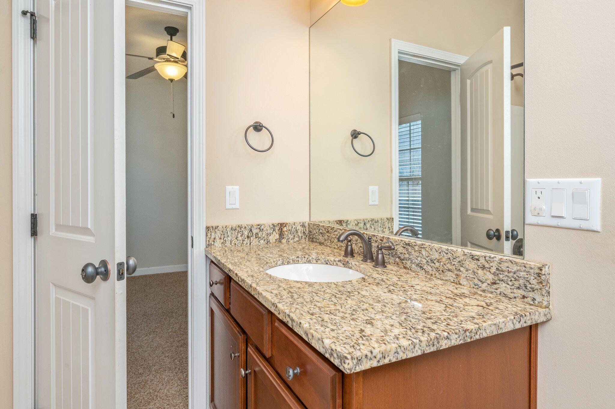 4434 Mirada Way Crestview, FL 32539 - Photo 32 of 42 a bathroom with a granite countertop sink and a mirror