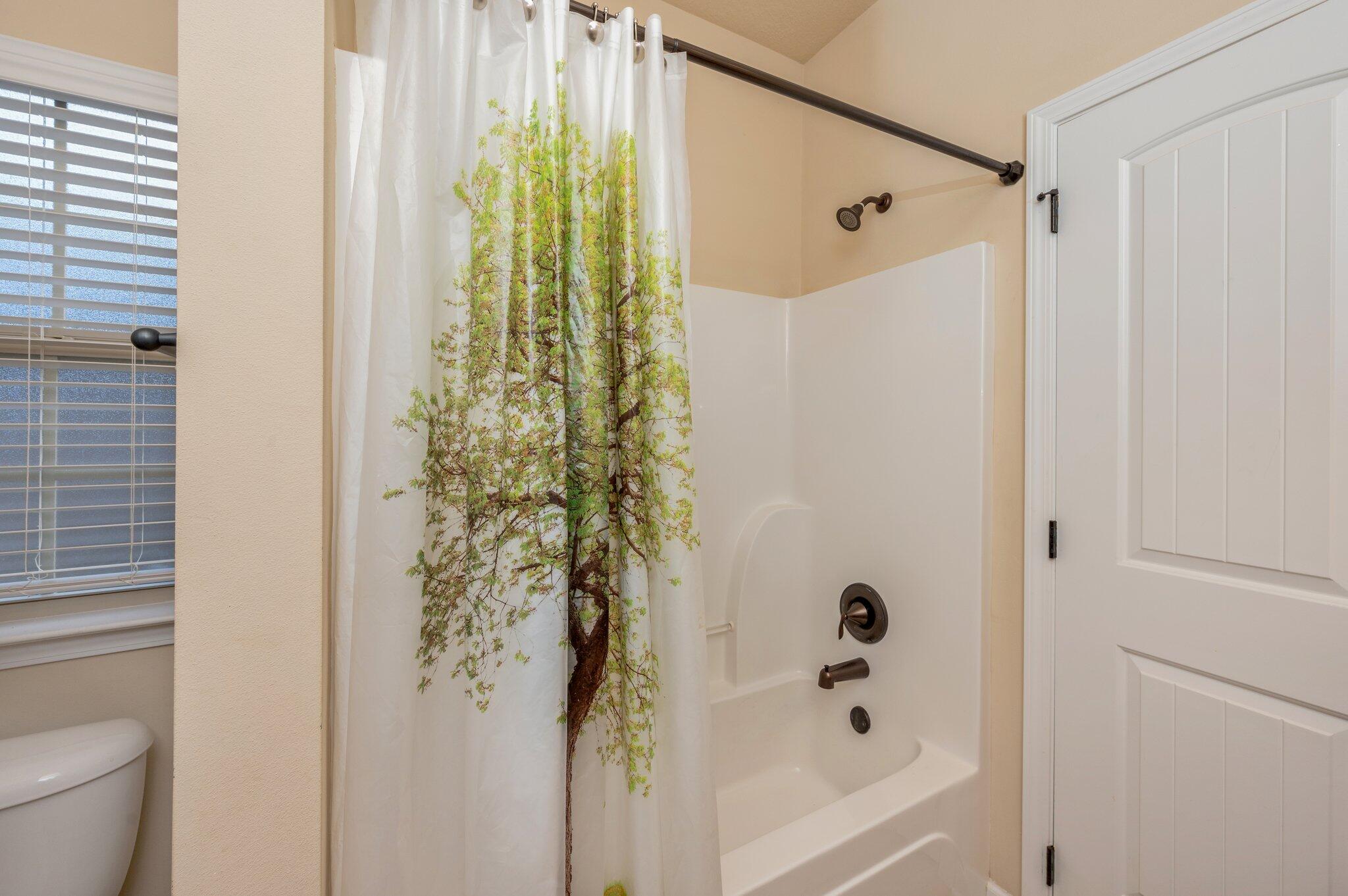 4434 Mirada Way Crestview, FL 32539 - Photo 33 of 42 a bathroom with a shower curtain and a toilet