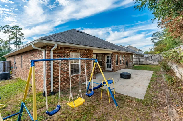 a view of a house with backyard and sitting area