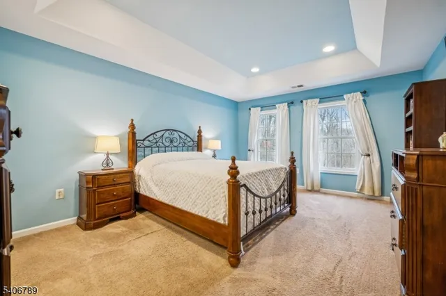 a bedroom with a bed a large window and dresser