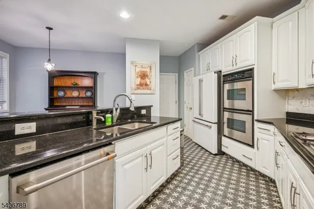 a kitchen with stainless steel appliances a stove a sink a microwave and cabinets