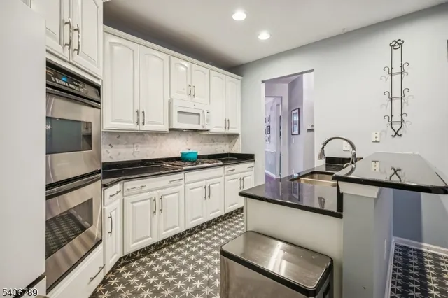 a kitchen with stainless steel appliances granite countertop a sink stove and cabinets