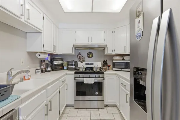 a kitchen with stainless steel appliances granite countertop a refrigerator sink and stove