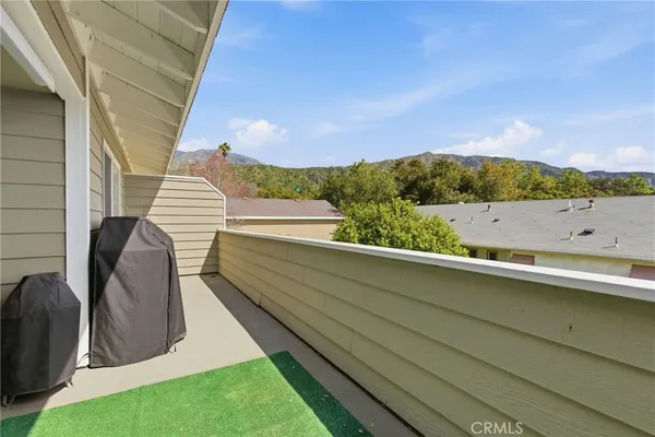 a view of a patio with couches table and chairs under an umbrella