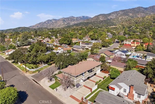 an aerial view of residential house with parking and mountain view
