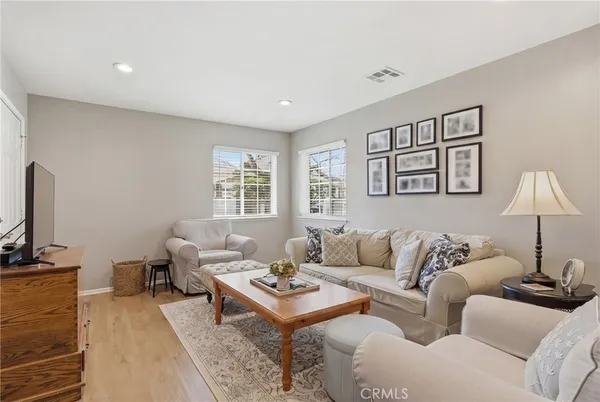 a kitchen with stainless steel appliances granite countertop a refrigerator a stove a sink dishwasher and a dining table with wooden floor