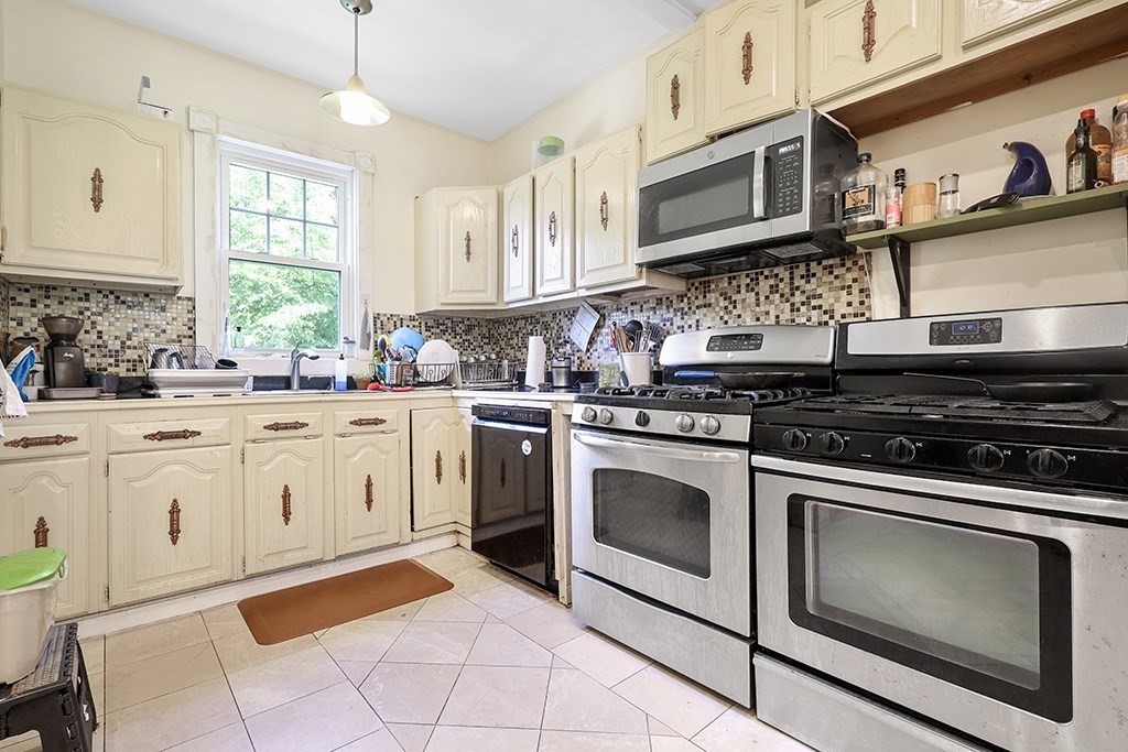 70 Peter Parley Road Boston, MA 02130 - Photo 16 of 35 a kitchen with stainless steel appliances granite countertop a stove a sink and a microwave