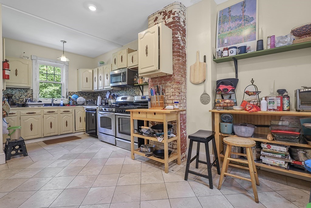 70 Peter Parley Road Boston, MA 02130 - Photo 17 of 35 a kitchen with stainless steel appliances granite countertop a sink and cabinets