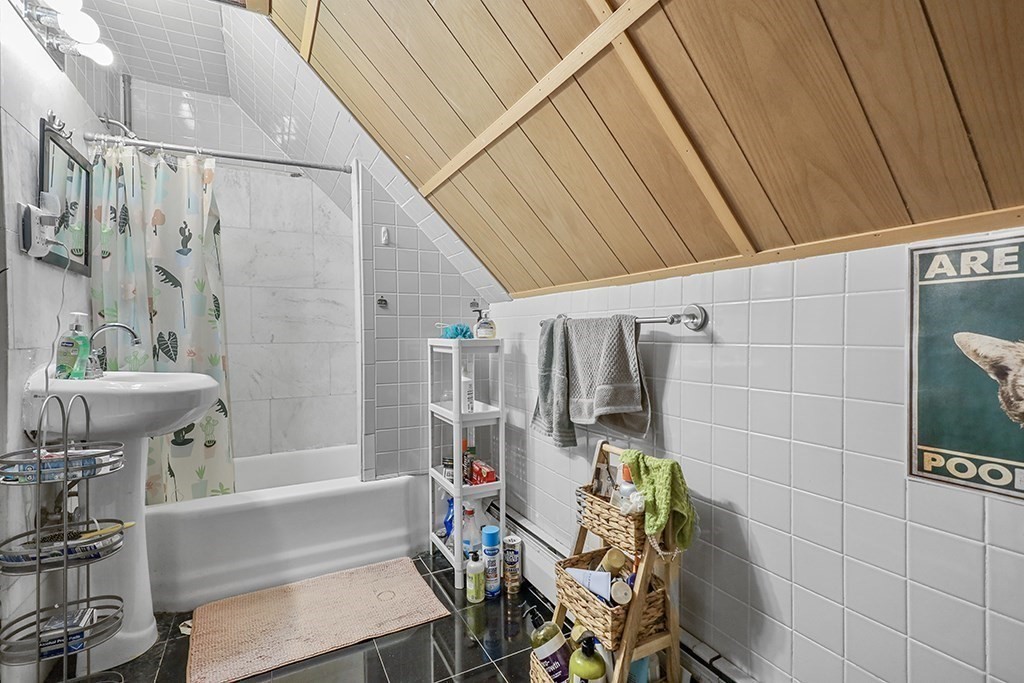 70 Peter Parley Road Boston, MA 02130 - Photo 27 of 35 a bathroom with a bathtub a sink and a shower curtain