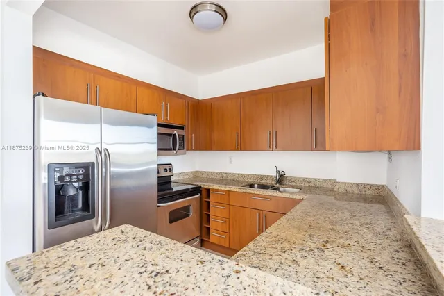 a kitchen with stainless steel appliances granite countertop a sink refrigerator and cabinets