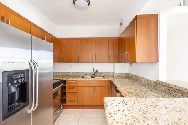 a kitchen with a sink a refrigerator and cabinets