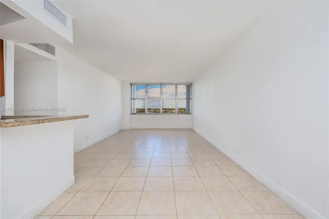 a view of a kitchen with an empty space and a window