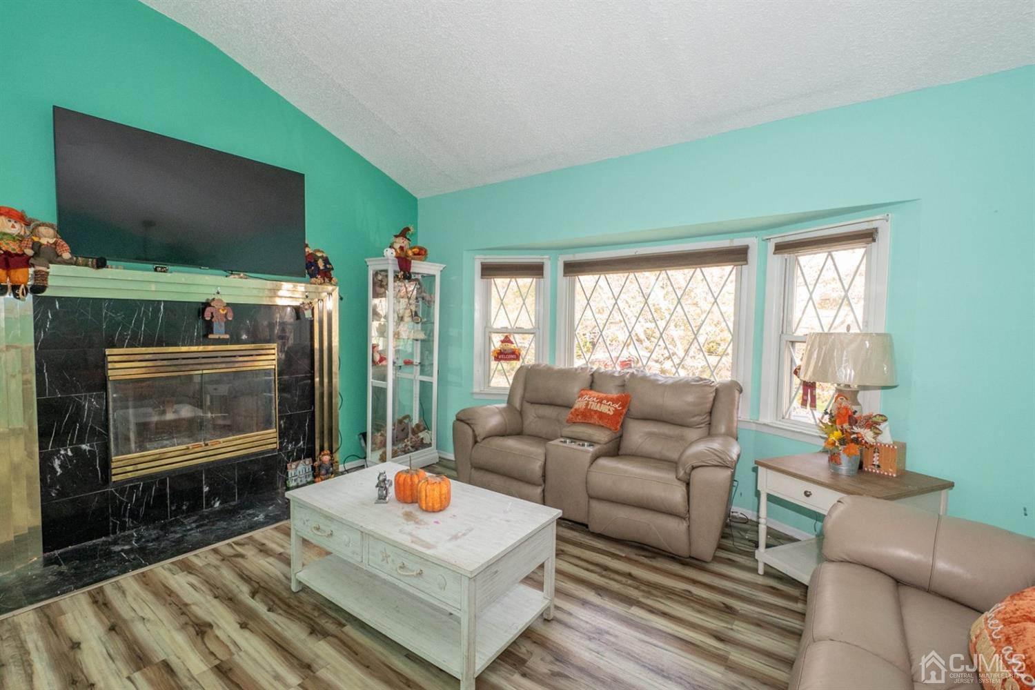 4 Hansen Road Old Bridge, NJ 08857 - Photo 10 of 39 a living room with furniture a flat screen tv and a fireplace
