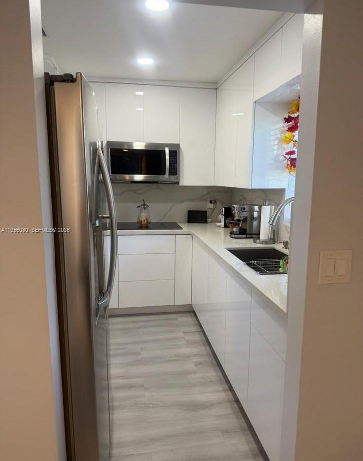 1327 Towhee Street Homestead, FL 33035 - Photo 26 of 31 a kitchen with a sink a refrigerator and cabinets