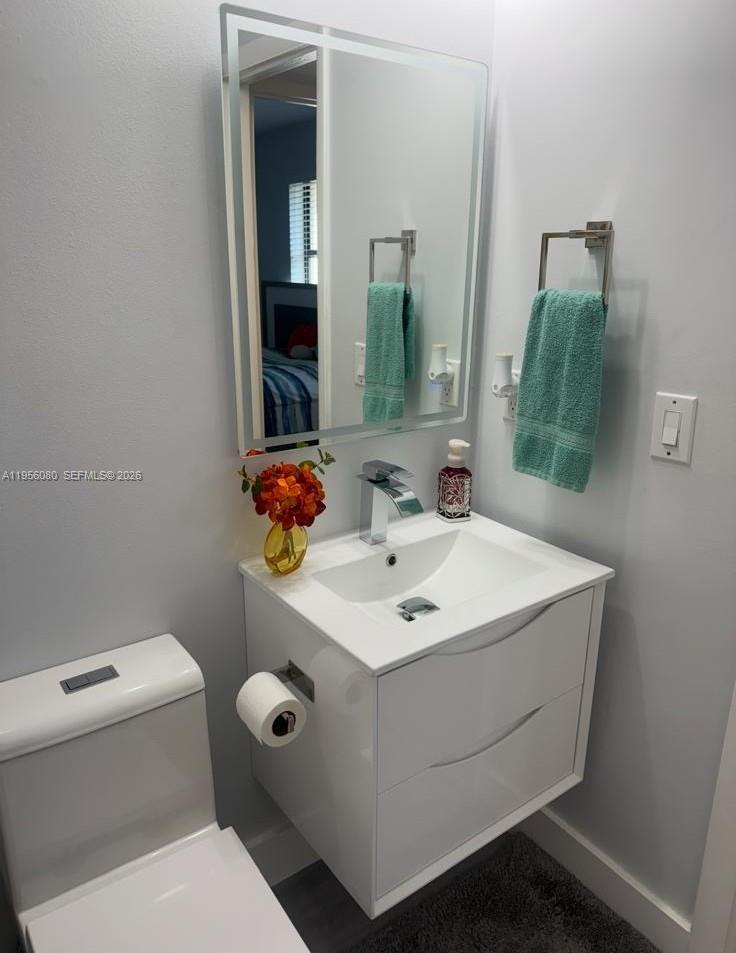 1327 Towhee Street Homestead, FL 33035 - Photo 28 of 31 a bathroom with a toilet sink and mirror