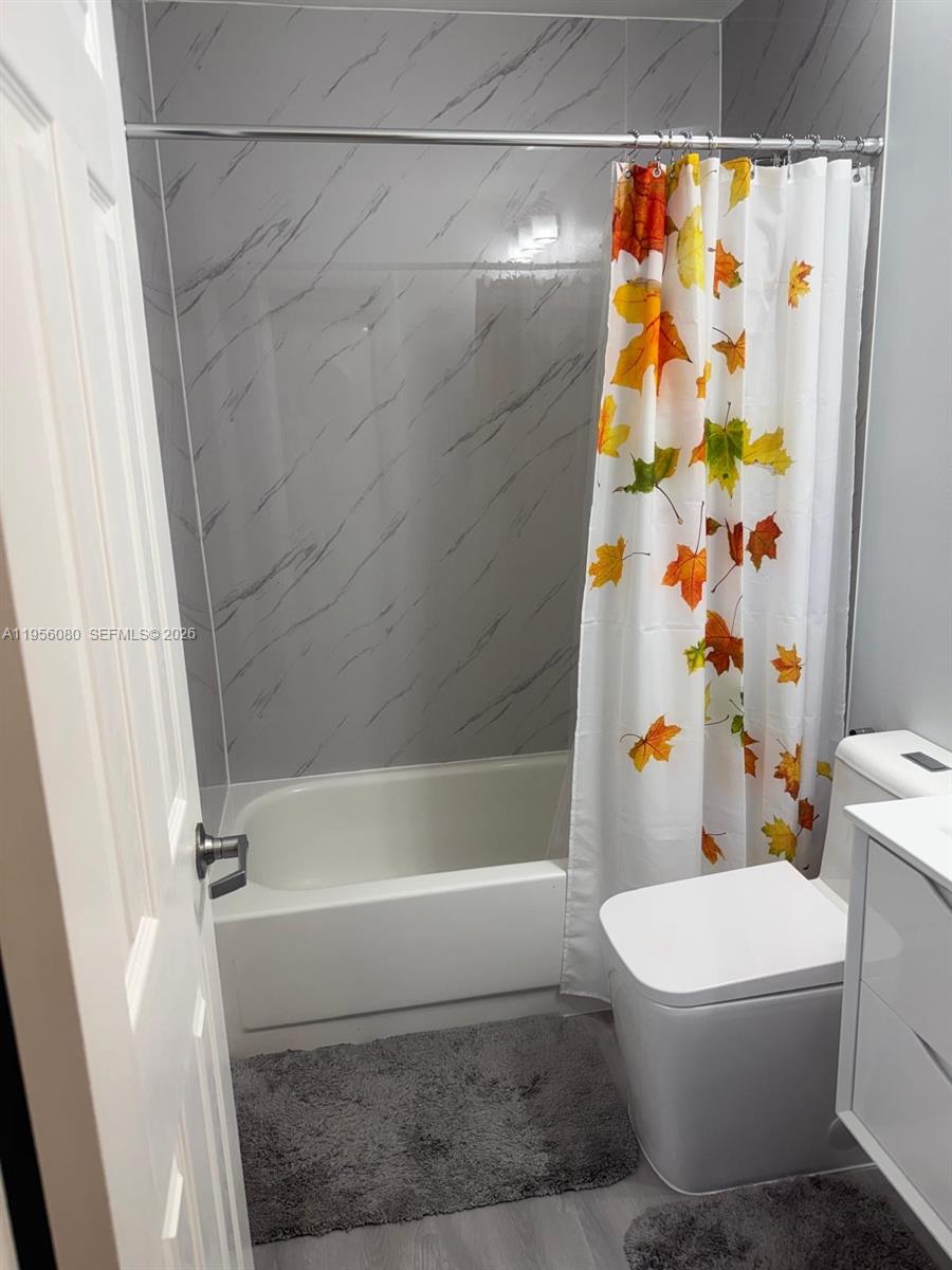 1327 Towhee Street Homestead, FL 33035 - Photo 10 of 31 a bathroom with a toilet and a shower curtain