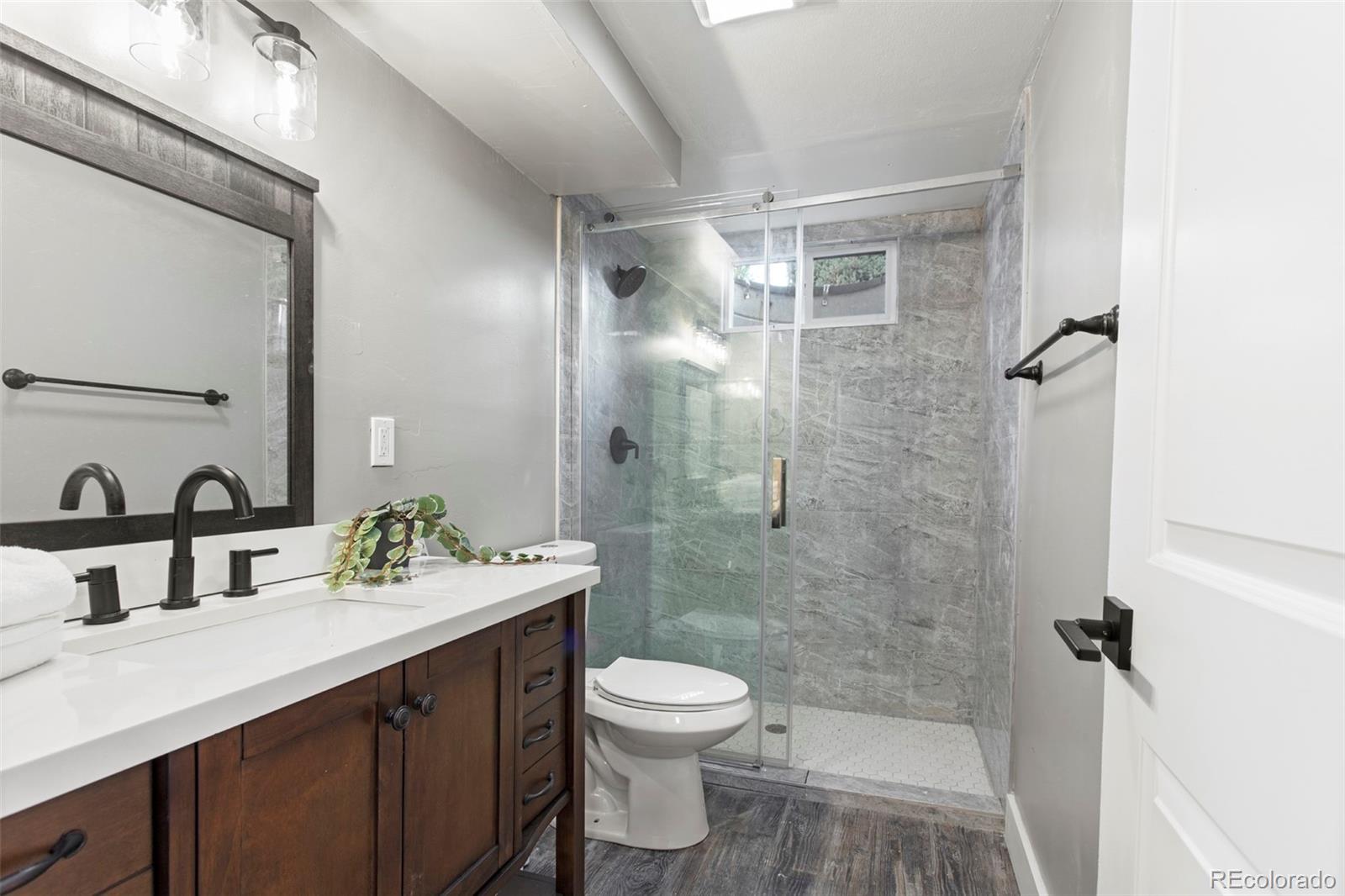 8060 Stuart Place Westminster, CO 80031 - Photo 12 of 18 a bathroom with a sink a toilet and shower