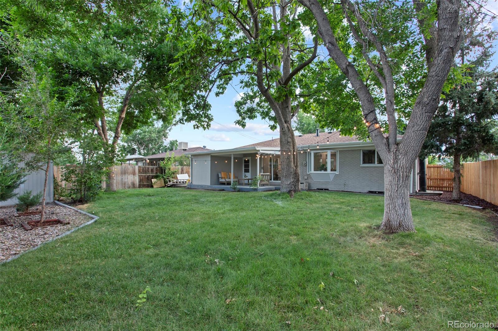 8060 Stuart Place Westminster, CO 80031 - Photo 16 of 18 a front view of a house with a garden and porch