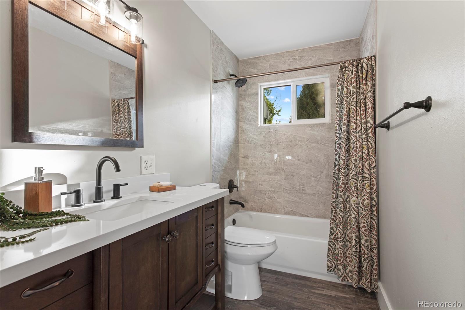 8060 Stuart Place Westminster, CO 80031 - Photo 7 of 18 a bathroom with a sink a toilet and shower