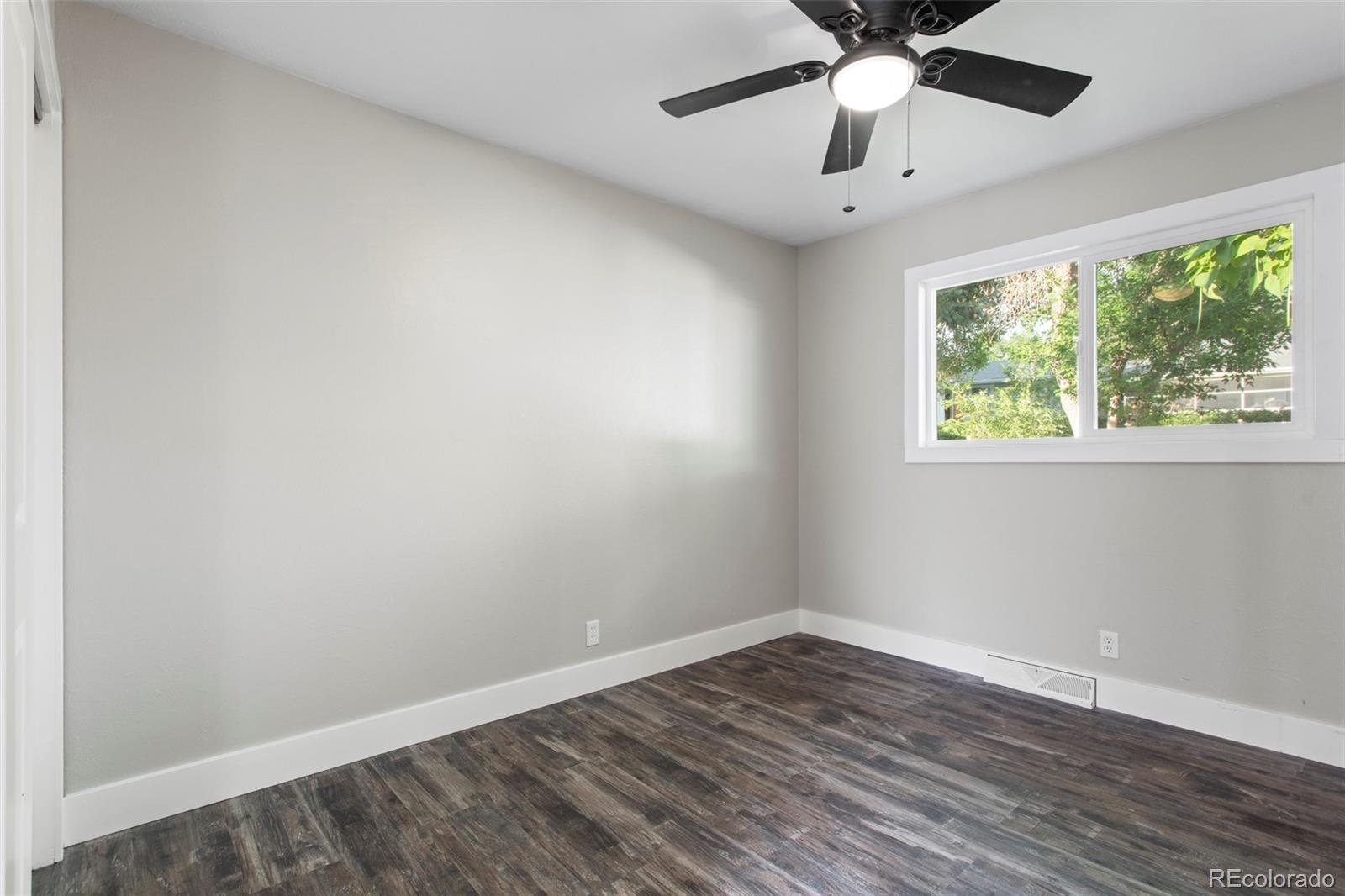 8060 Stuart Place Westminster, CO 80031 - Photo 9 of 18 wooden floor in an empty room with a window