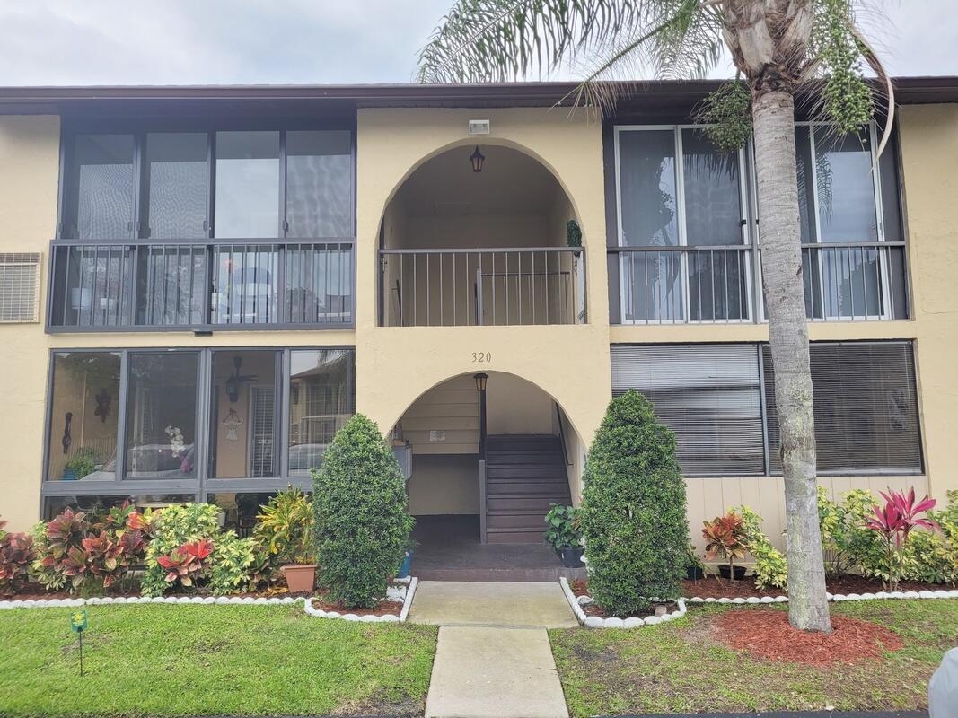 320 Pine Ridge Circle, Unit A1 Greenacres, FL 33463 - Photo 1 of 65 a front view of a house with garden