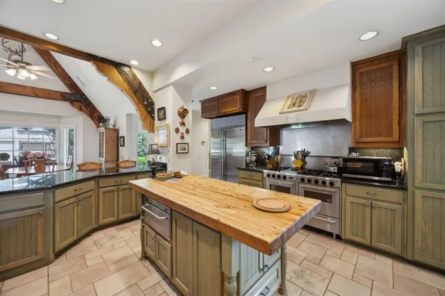a kitchen with a sink a stove top oven and cabinetry