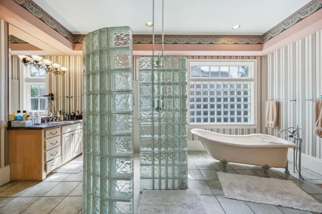 a bathroom with a double vanity sink a toilet and shower