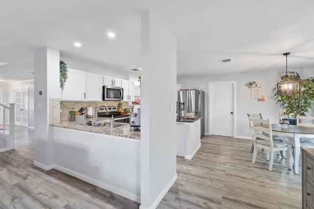 a kitchen with stainless steel appliances kitchen island granite countertop a refrigerator and a stove top oven