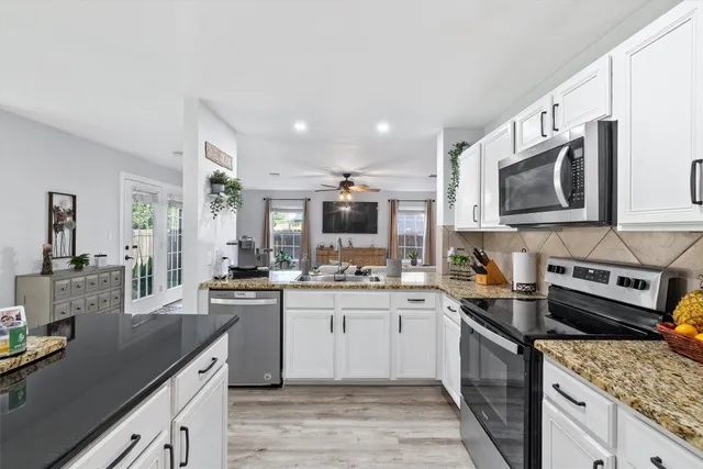 a kitchen with a sink stove top oven and refrigerator
