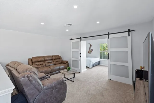 a living room with furniture and a ceiling fan