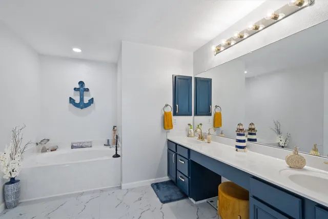 a bathroom with a tub sink and mirror