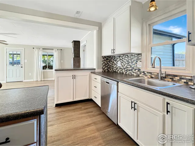 a kitchen with granite countertop white cabinets and white appliances