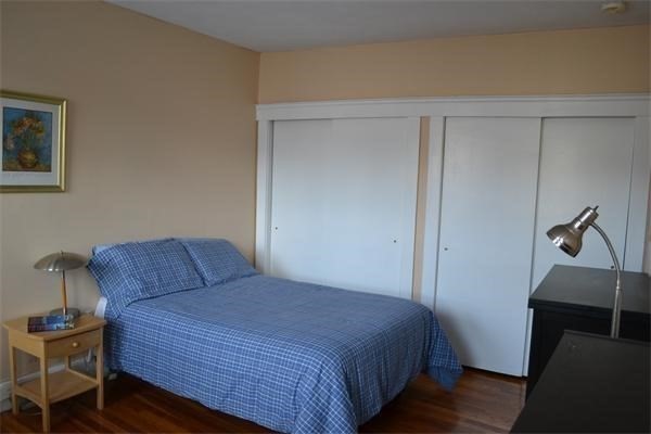 110 Lanark Road, Unit 5 Boston, MA 02135 - Photo 5 of 17 a bedroom with a bed and wooden floor
