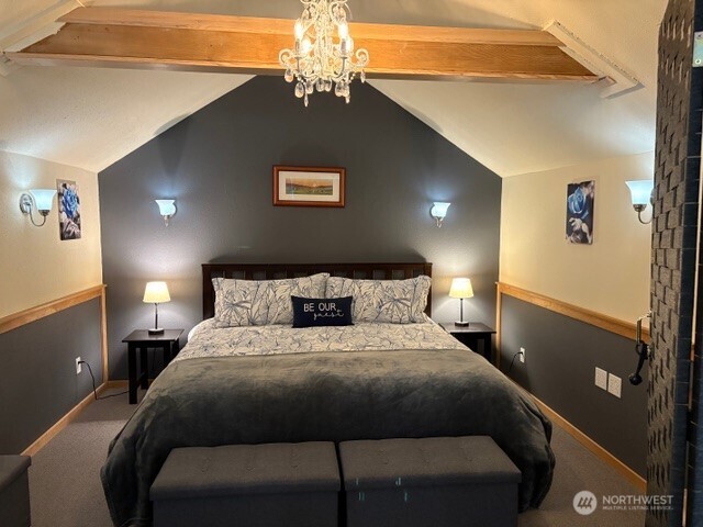 5024 Saratoga Road, Unit STUDIO Langley, WA 98260 - Photo 11 of 17 a bedroom with a bed and a chandelier