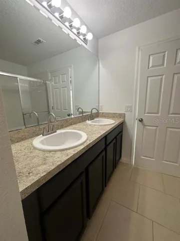 a bathroom with a granite countertop sink a mirror and a vanity