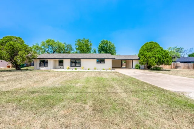 a house with green field in front of it