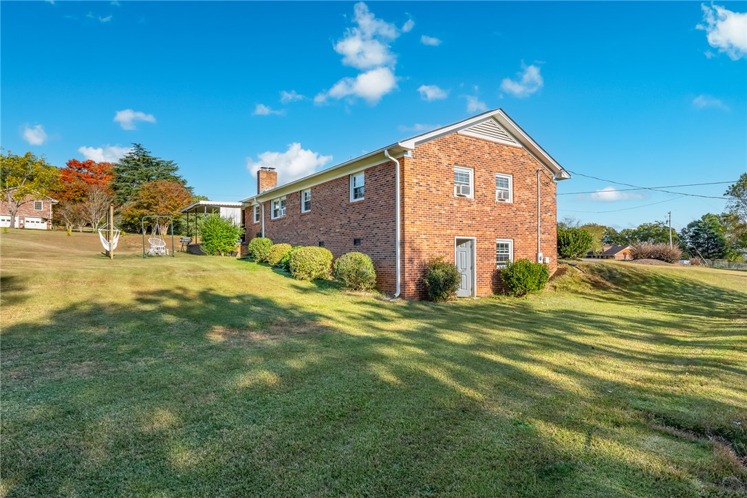 401 South Glassy Mountain Road Pickens, SC 29671 - Photo 33 of 37 This classic brick residence features a lush, expansive yard and mature landscaping under a brilliant sky.