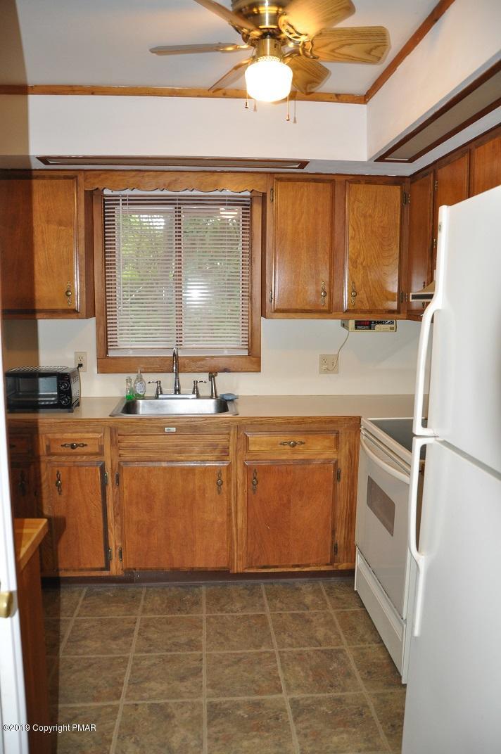 1041 Clover Road South Long Pond, PA 18334 - Photo 5 of 26 a kitchen with granite countertop a refrigerator a sink a stove and white cabinets