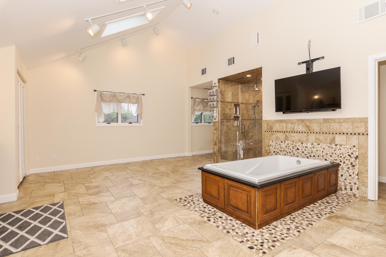 1810 Cardinal Court Pontiac, IL 61764 - Photo 42 of 88 a spacious bathroom with a tub a mirror and a flat screen tv