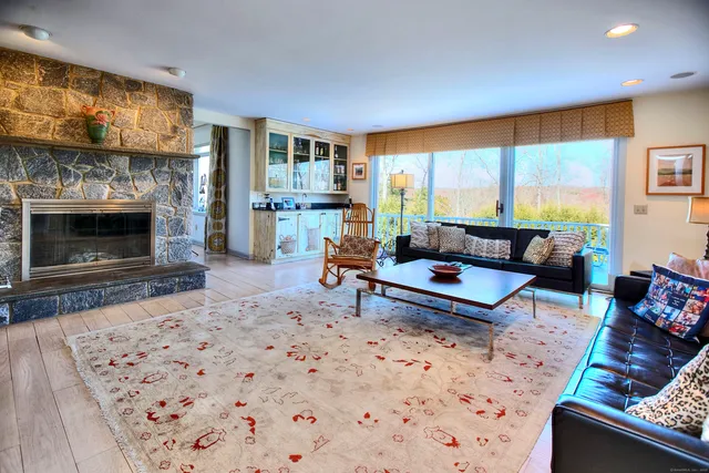 a living room with furniture a large window and a fireplace
